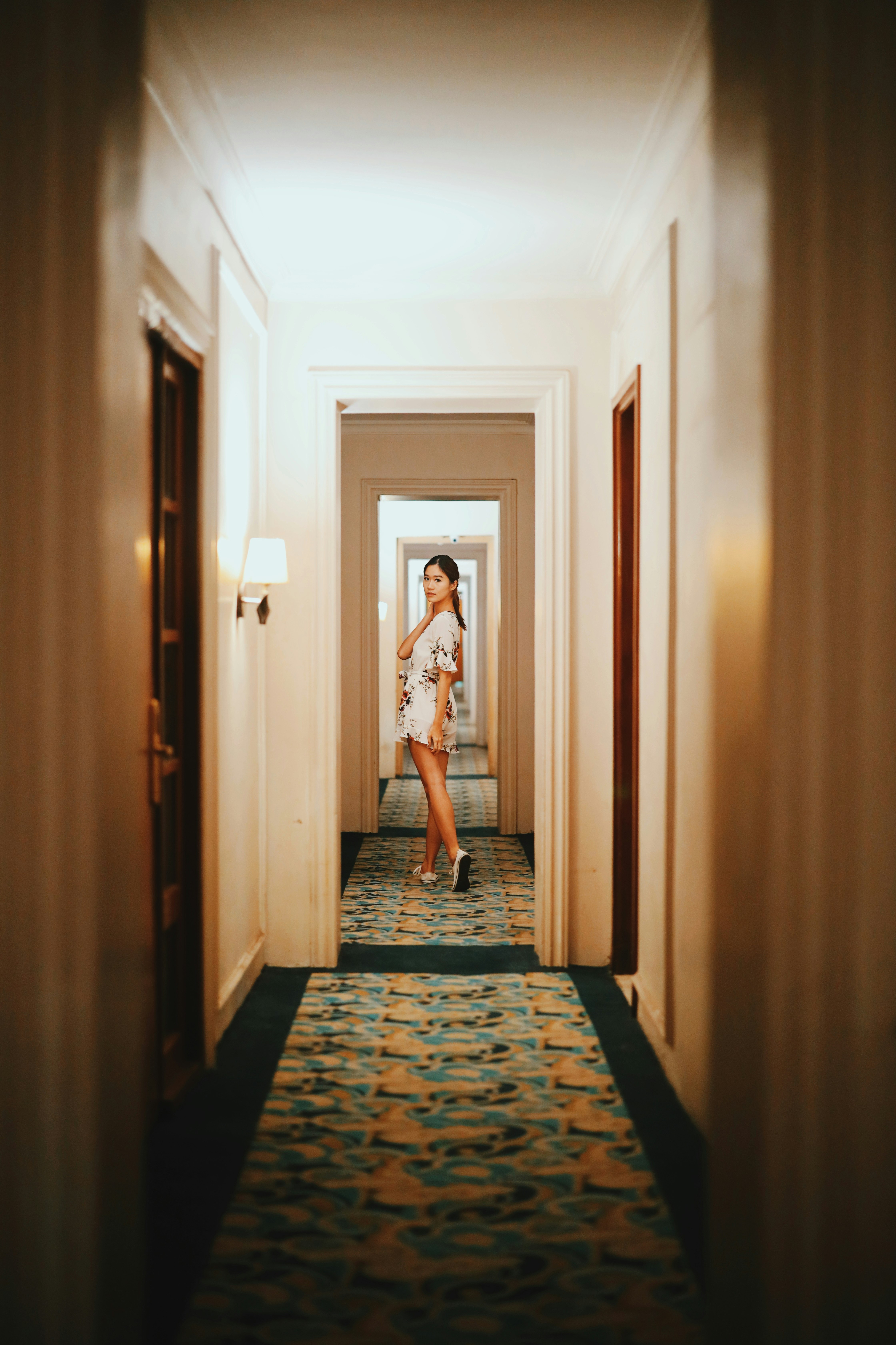woman in white and black dress standing on hallway